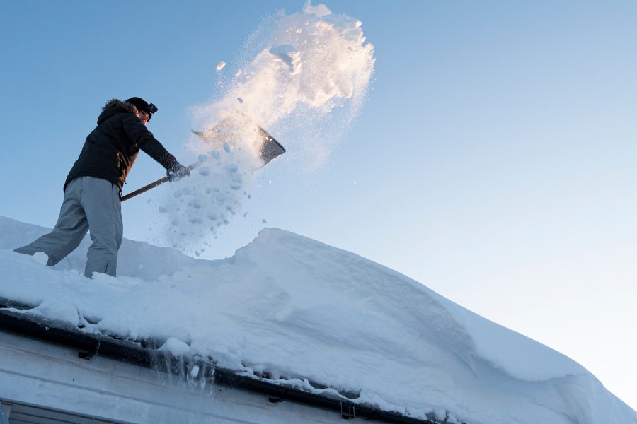 Calgary homeowner removing snow off roof 