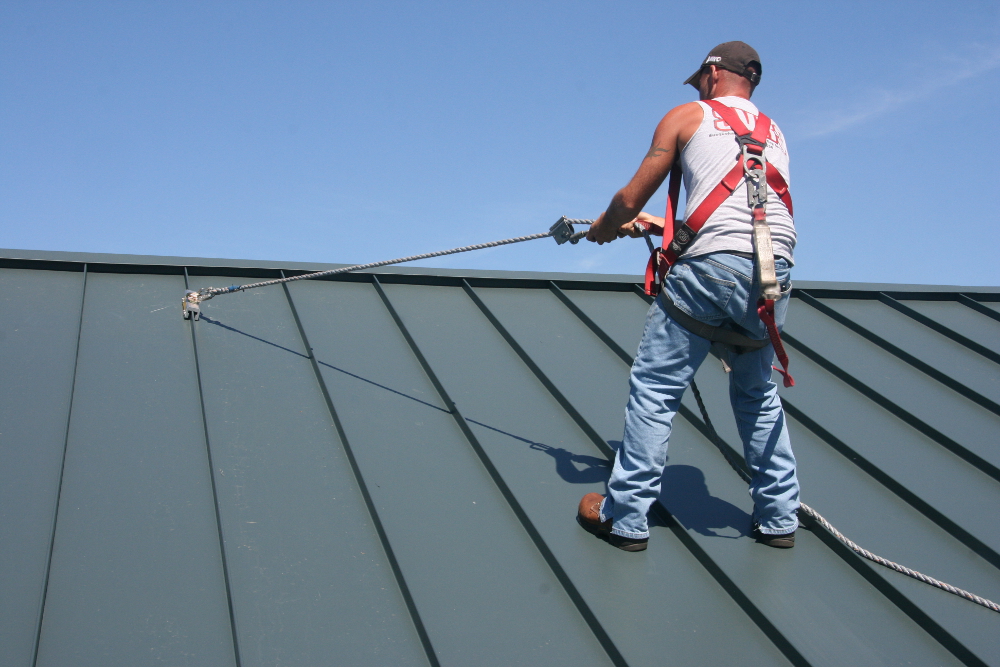 Person using anchor and harness to secure themselves on roof