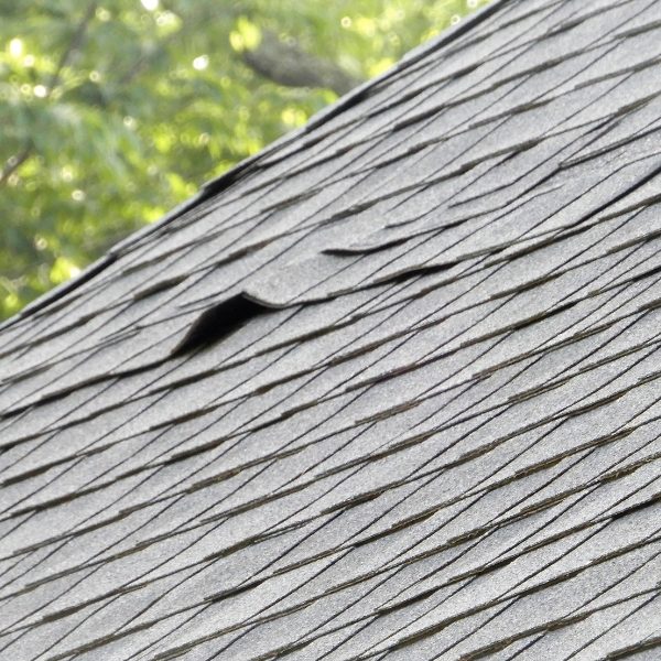 Damaged roof shingles on residential home 