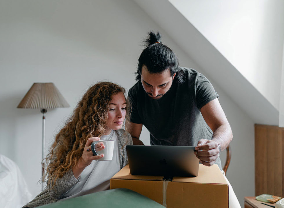 Two people looking at a laptop in a home