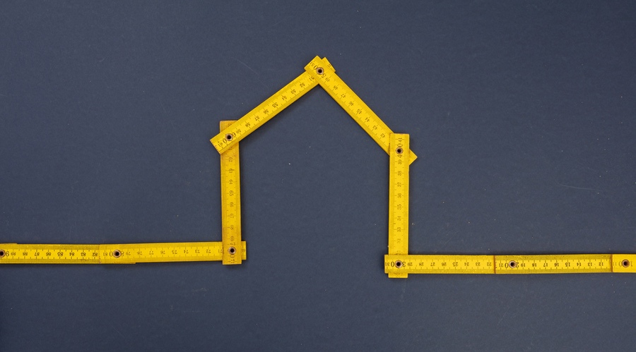 Tape measure arranged in shape of home to symbolize measuring process for gutters
