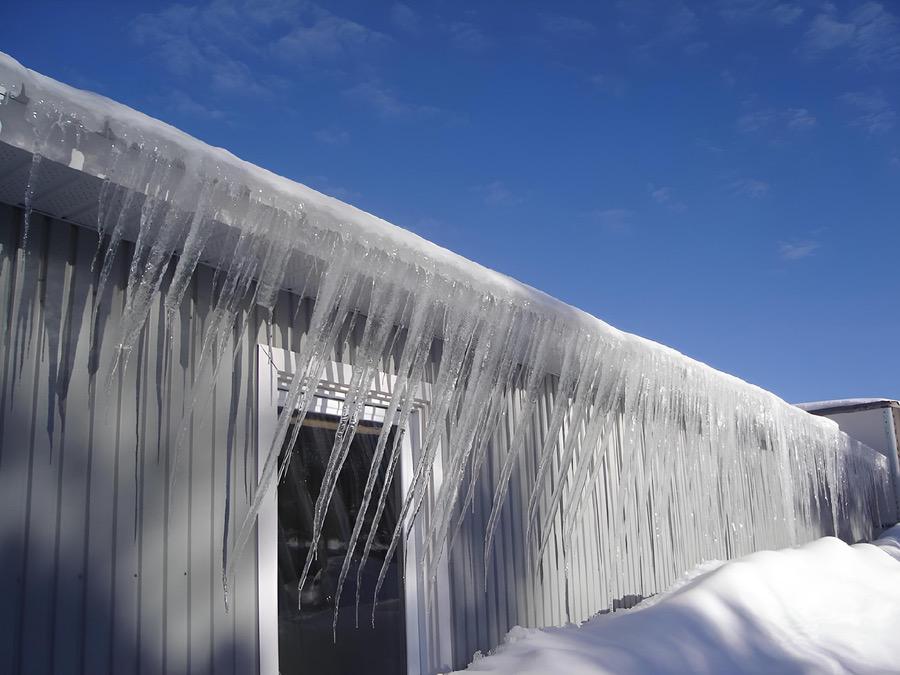 Ice dams forming on eavestroughs of home in winter