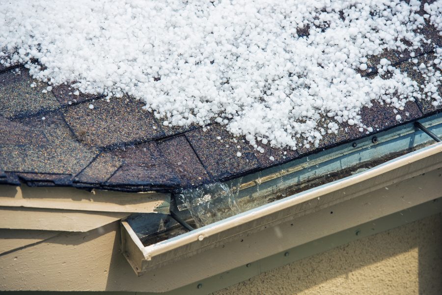 A close-up of hail on an asphalt shingle roof.