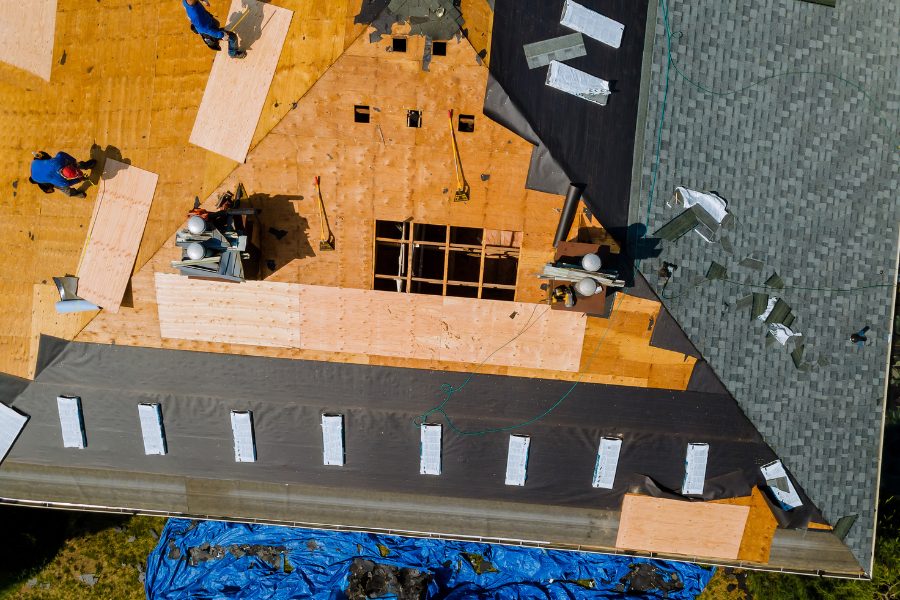 A professional roofing crew removes old asphalt shingles and installs a new roof.